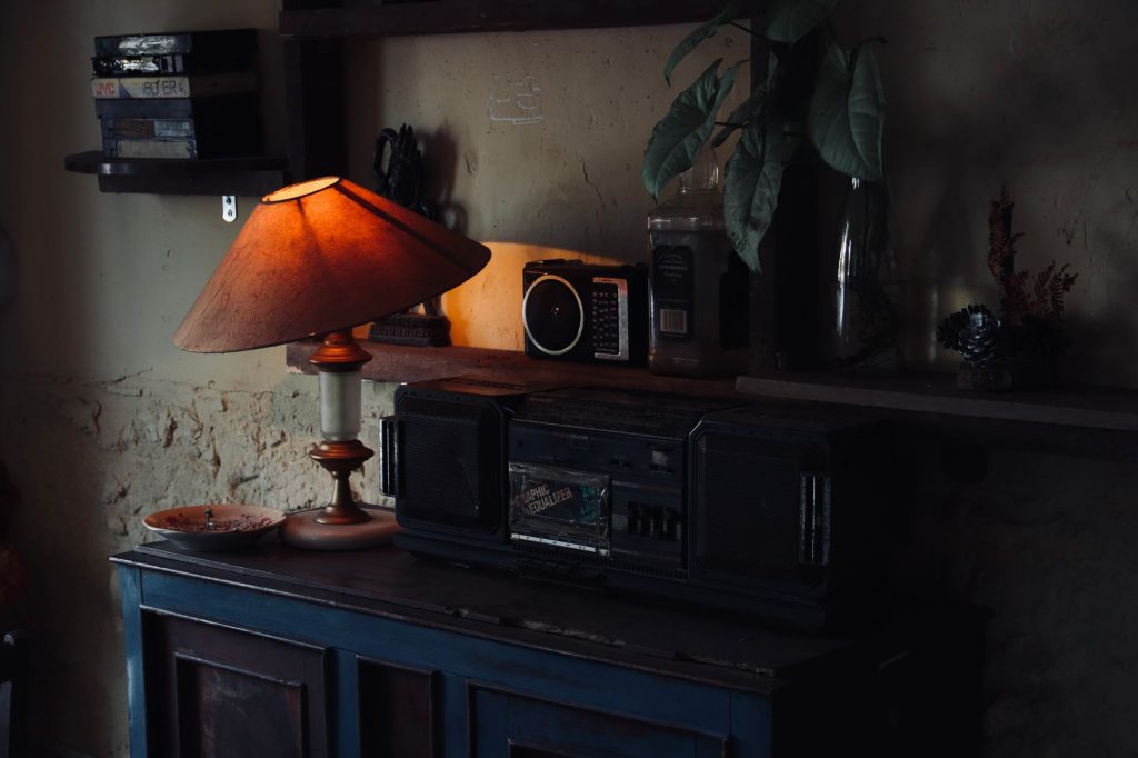 Cozy vintage interior with a warm lamp illuminating a wooden cabinet and retro radio.