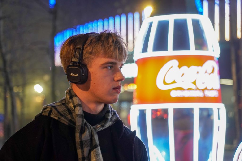 Man enjoying music in front of neon lights in Kyiv, Ukraine at night.