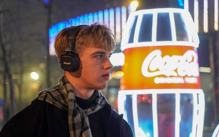 Man enjoying music in front of neon lights in Kyiv, Ukraine at night.