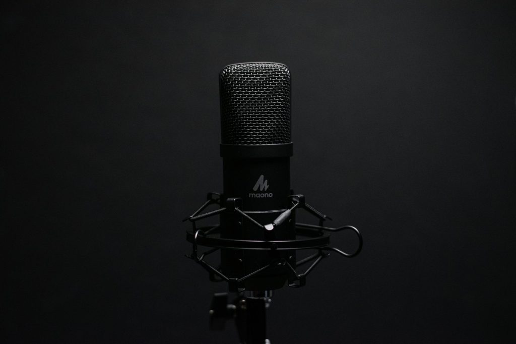 Studio microphone with shock mount on a dark backdrop, perfect for audio recording setups.