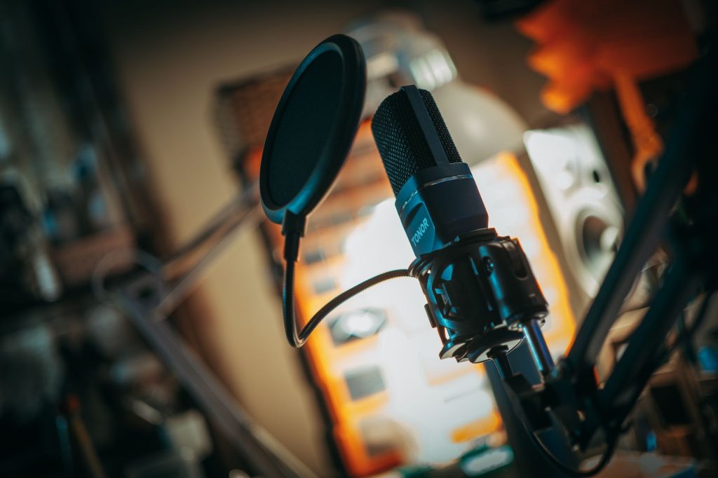 Close-up of a microphone with pop filter in a recording studio, perfect for music production visuals.