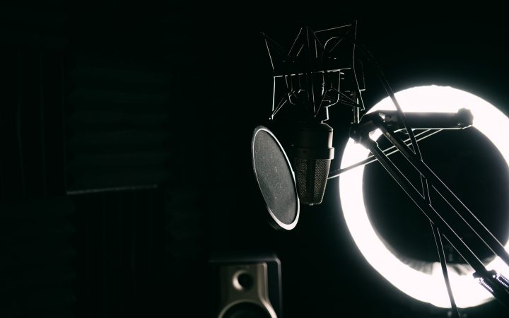 Close-up of a studio microphone with pop filter and ring light, ideal for music recording.