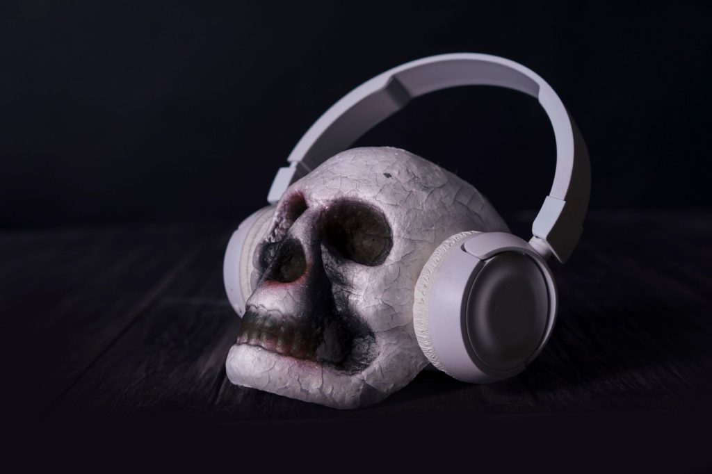 A close-up of a skull wearing headphones in a dark, moody setting, ideal for dramatic themes.