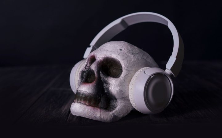 A close-up of a skull wearing headphones in a dark, moody setting, ideal for dramatic themes.