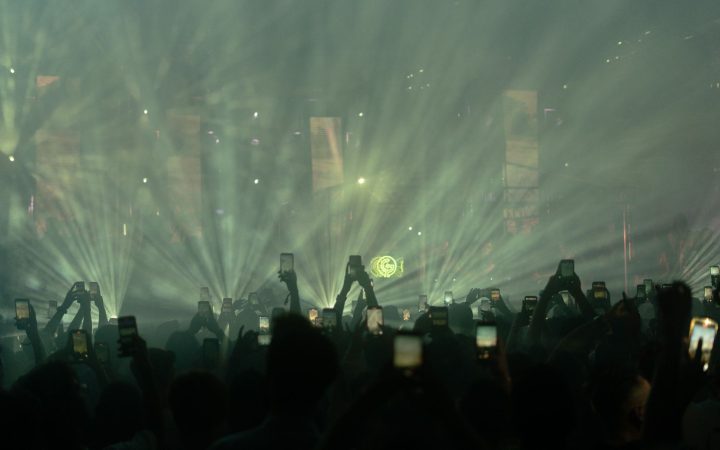 Dynamic crowd at a night music festival in Istanbul with bright stage lights.