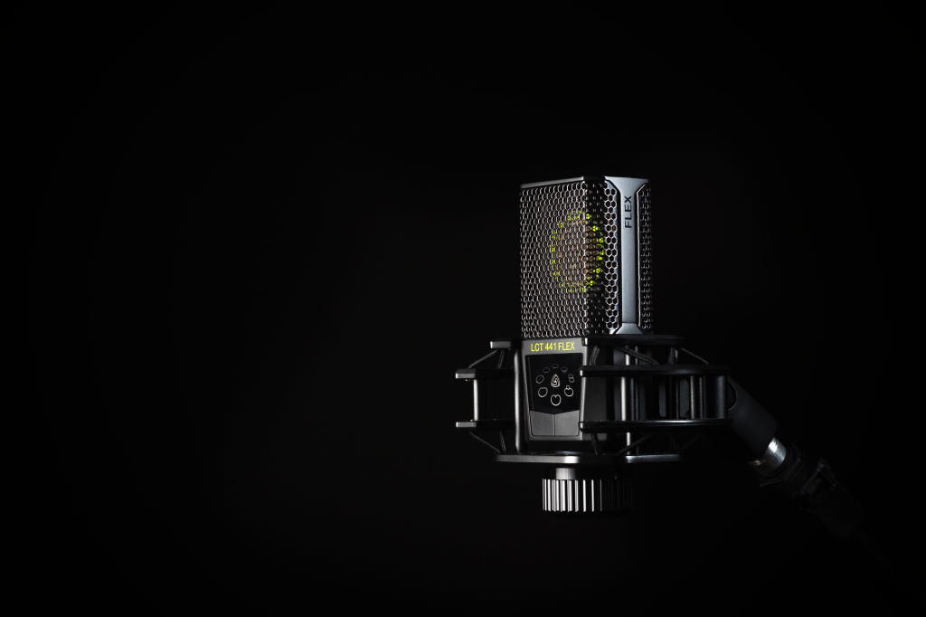A detailed studio shot of a condenser microphone against a black background, emphasizing modern audio technology.