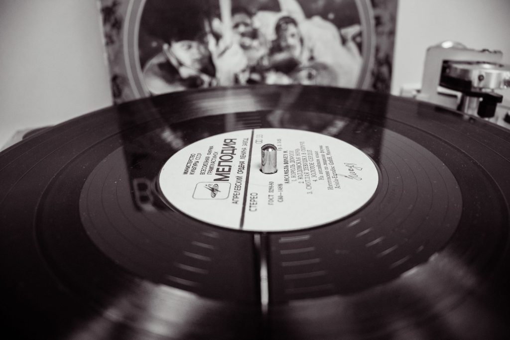 Black and white close-up of a spinning vinyl record on a turntable.
