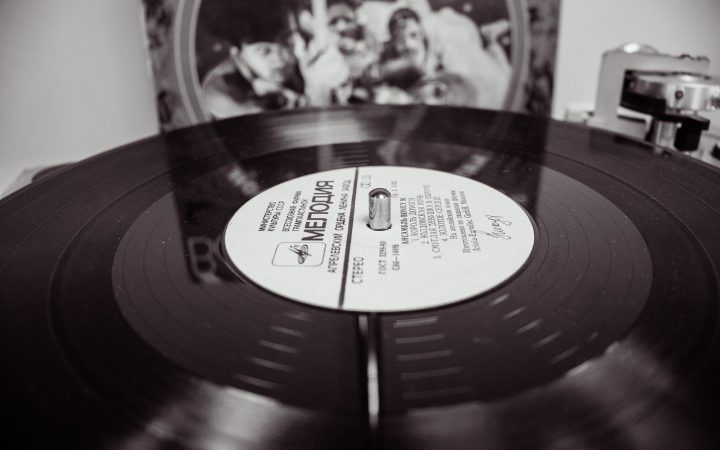 Black and white close-up of a spinning vinyl record on a turntable.
