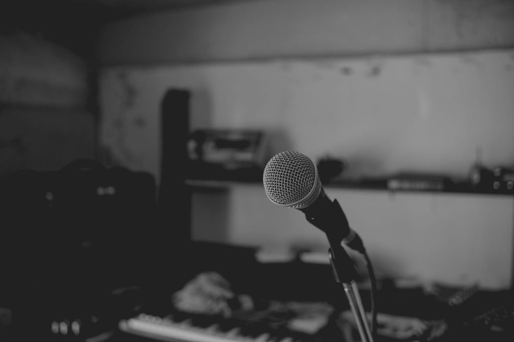 Artistic black and white shot of a music studio with a focus on a microphone. Perfect for music-themed projects.