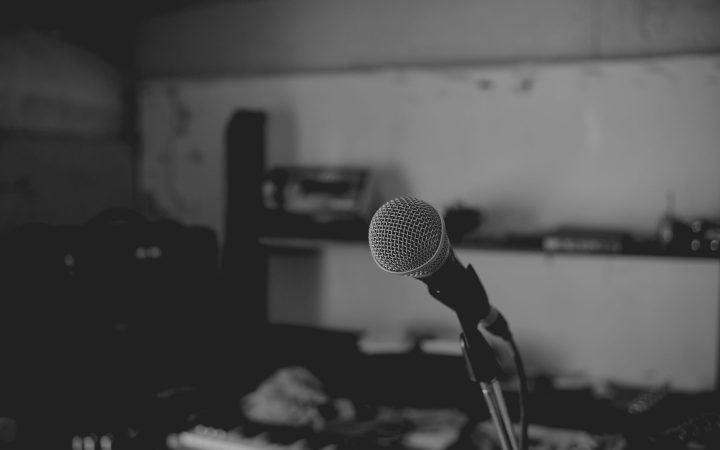 Artistic black and white shot of a music studio with a focus on a microphone. Perfect for music-themed projects.