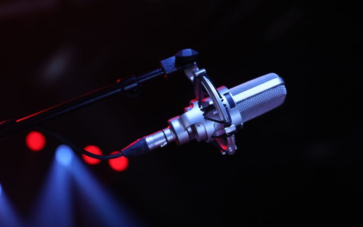 Close-up of a professional microphone on a stage with vibrant lighting in Paris, France.