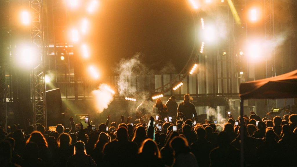 Captivating live concert scene with crowd and bright stage lights at night.