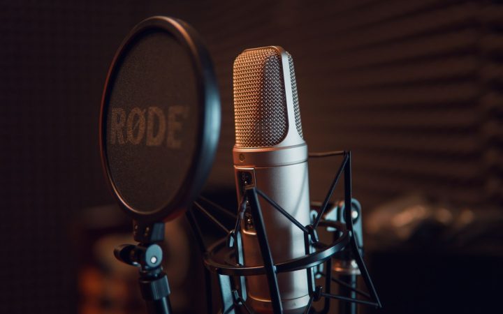 Close-up of a studio microphone with pop filter, ideal for recording audio.