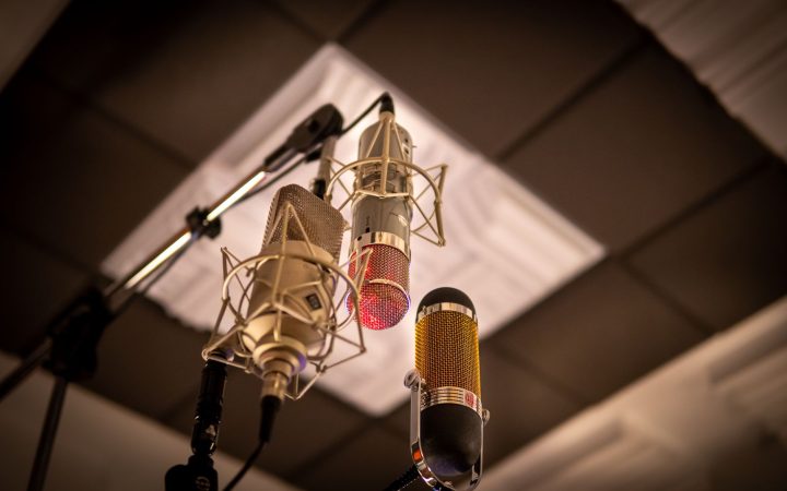 Three condenser microphones arranged for optimal sound capture in a recording studio.